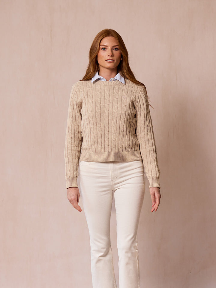A woman modeling the Malt pink cable-knit sweater