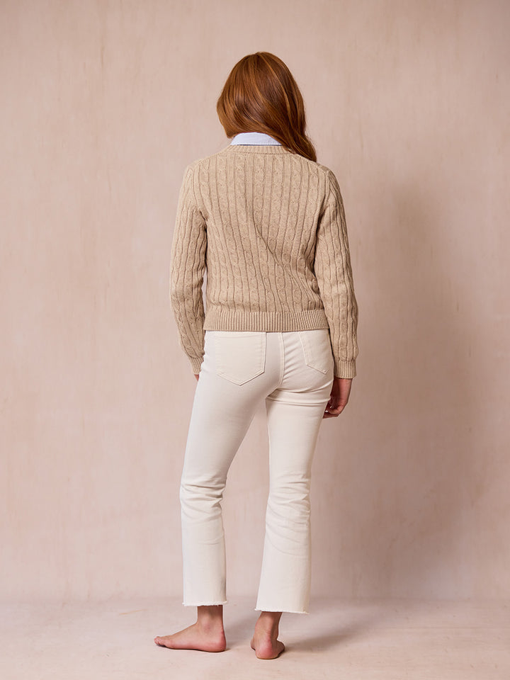 A woman modeling the Malt pink cable-knit sweater from behind